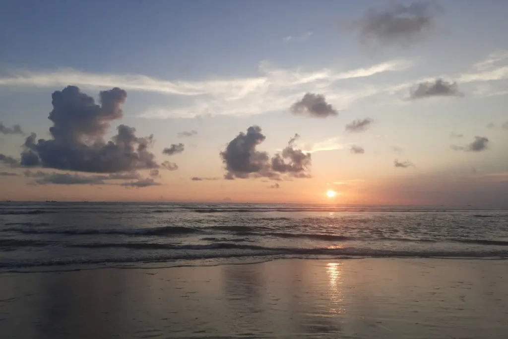 Captivating view of a beach sunset with dramatic clouds and gentle waves. Beach Captions for Instagram