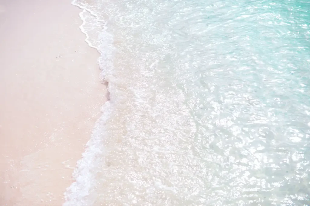 Tranquil scene of waves on a white sand beach, clear turquoise waters. Beach Captions for Instagram